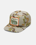 The Volcom Men's Stoney River Hat features a tan and green camouflage design with a patch that reads “Stoney River, Go With The Flow” above a river scene. This cap offers a flat brim, 5-panel foam crown, adjustable snapback fit, and an adjustable back for added comfort.