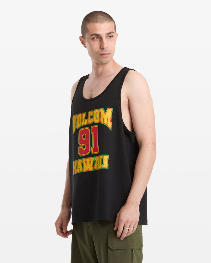 A man with short hair wears the Volcom Men's Swish Tank, a loose black tank top with yellow and red VOLCOM 91 HAWAII lettering, and olive green cargo shorts, standing against a plain white background.