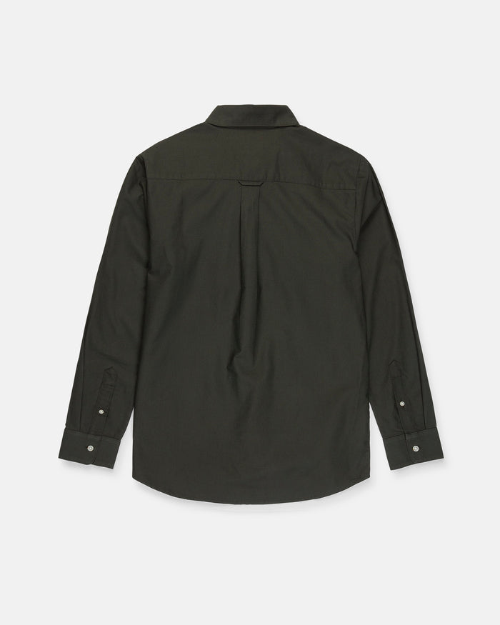 The Men's Veeco Oxford Long Sleeve Shirt by Volcom is pictured from the back in Climbing Ivy green, showcasing a classic fit with a collar, buttoned cuffs, and a central pleat beneath the yoke. Made from soft micro suede fabric, it combines comfort with timeless style.