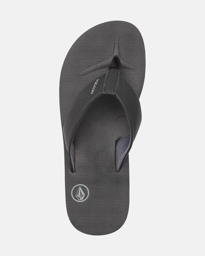 The Volcom Men's Victor Sandals are black flip-flops with textured straps, a Recliner Comfort Foam footbed, and the Volcom logo near the heel, shown from above on a white background. Water-friendly for all-day comfort and style.