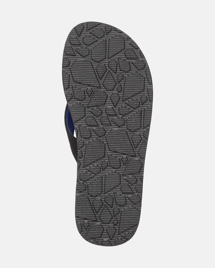 The image shows the sole of Volcom Men's Victor Sandals featuring a textured, irregular geometric pattern on a gray background. Its slightly curved shape and water-friendly design add versatility, with part of the blue insole visible.