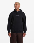 A man with short, light blond hair wears the Men's Volcom Stone Pullover by Volcom and brown pants, standing against a plain white background and looking slightly to the side.