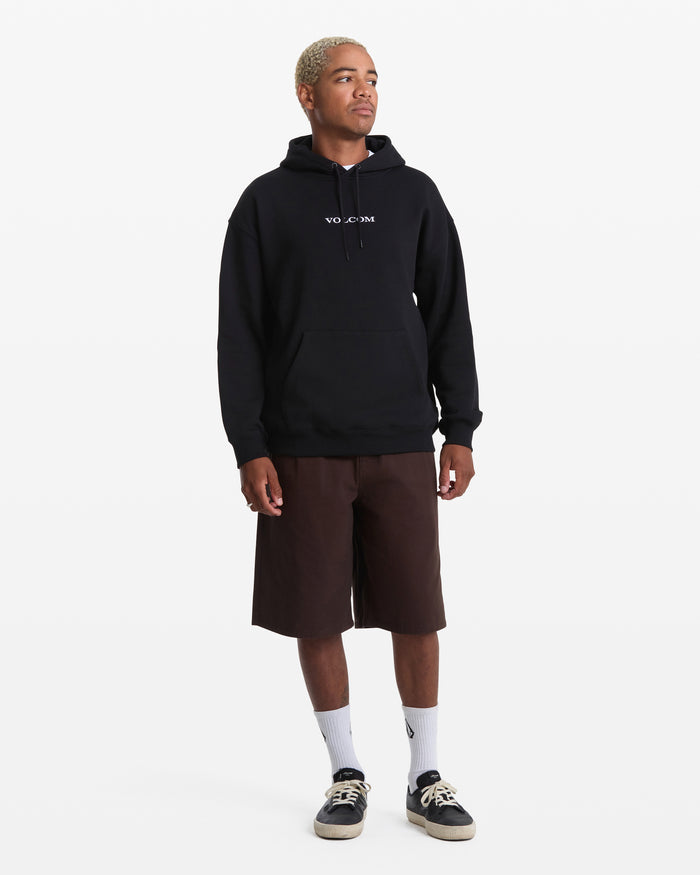 A person with short blond hair wears a Men's Volcom Stone Pullover by Volcom, styled with brown knee-length shorts, white socks, and black sneakers, standing against a plain white background.