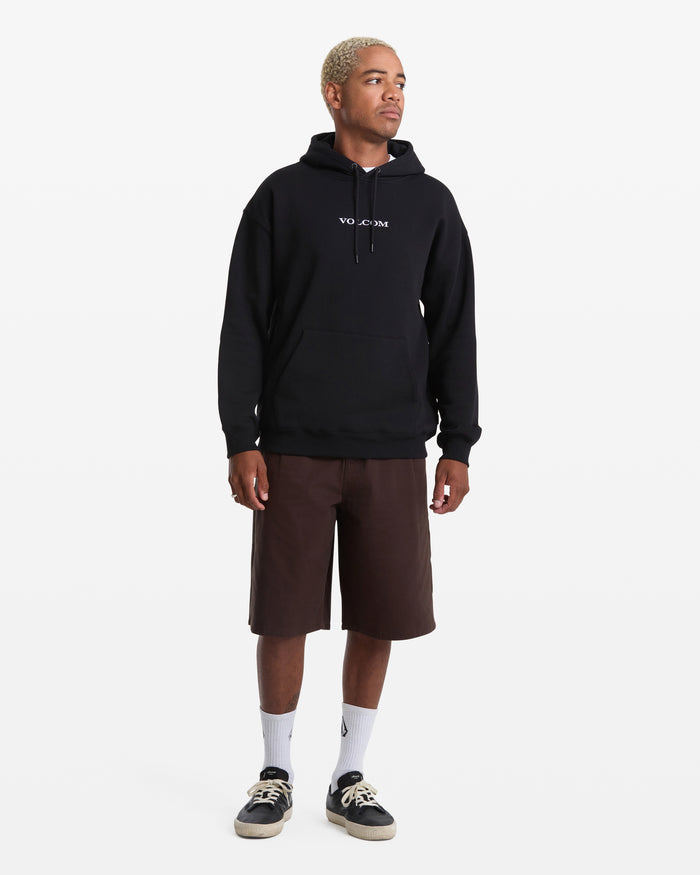 A person with short, bleached hair wears the Men's Volcom Stone Pullover by Volcom, paired with brown knee-length shorts, white socks, and black sneakers, standing against a plain white background.