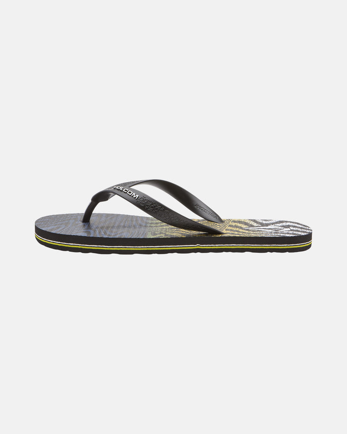 The Men's Volcomotion Mens flip-flop by Volcom features a black thong strap and a textured sole with a yellow and gray leaf pattern—blending summer style with everyday comfort, shown in side profile.