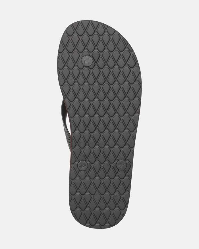 The image shows the bottom view of a single Volcomotion Mens flip-flop by Volcom, featuring a black, diamond-patterned textured rubber sole with circular markings on a plain light background.