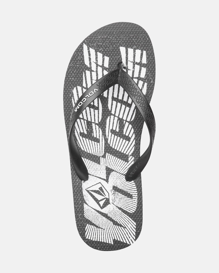 The Volcomotion Mens flip-flop by Volcom features a black textured sole, white abstract design, and VOLCOM branding on the strap and footbed.