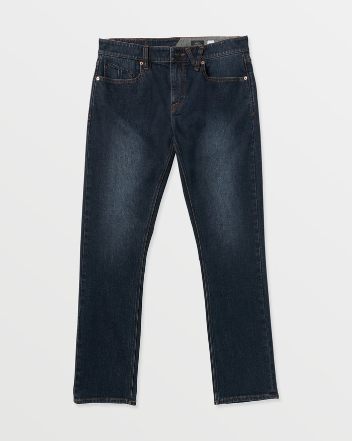 The Volcom Men's Vorta Denim features dark blue straight-leg jeans with classic five-pocket styling, visible stitching, and a button closure, shown laid flat on a white background.