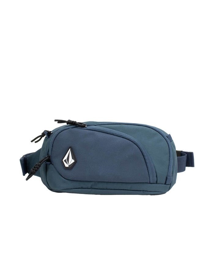 The Volcom Men's Waisted Pack is a blue waist pack featuring a front zipper pocket, black zipper pulls, and a distinctive black-and-white geometric Volcom logo on the front. Designed for outdoor adventures and hands-free convenience, it is displayed against a plain white background.