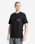 A man with short hair wears a Volcom Men's Warning Pocket Short Sleeve Tee in black, made from 100% cotton and featuring a chest pocket, paired with light gray shorts. He stands against a white background, looking off to the side.
