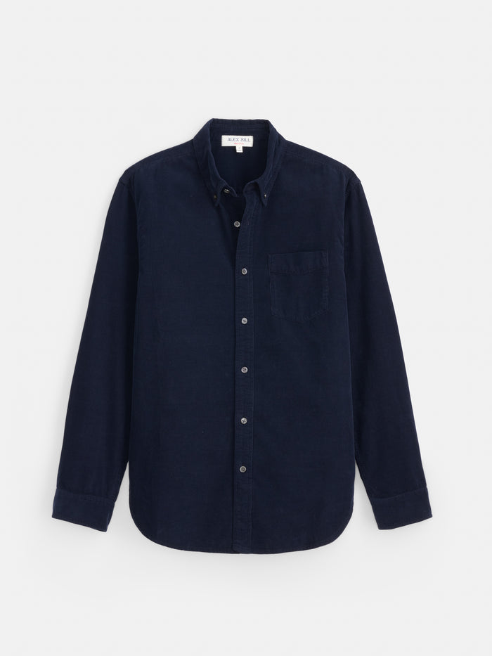 The Mill Shirt in Fine Wale Corduroy is a men’s long-sleeve, button-up shirt in navy blue, made from 100% cotton corduroy and featuring a chest pocket, shown laid flat on a white background.