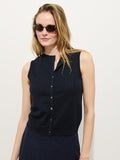 A woman in tortoiseshell sunglasses models the Odette Sweater Tank in Cotton Cashmere, a sleeveless dark navy button-up top, standing against a plain white background and looking off to the side with a relaxed expression.