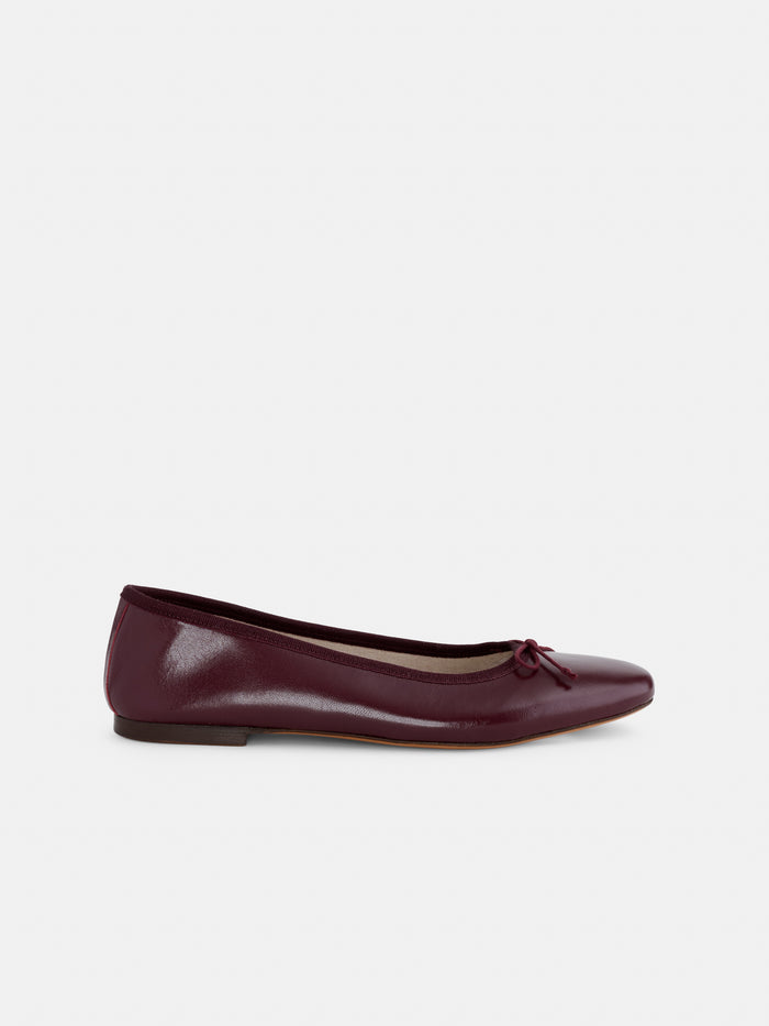 The Prince Street Ballet Flat in Leather, shown in maroon Italian leather with a small bow on the toe, is displayed from the side against a plain white background.