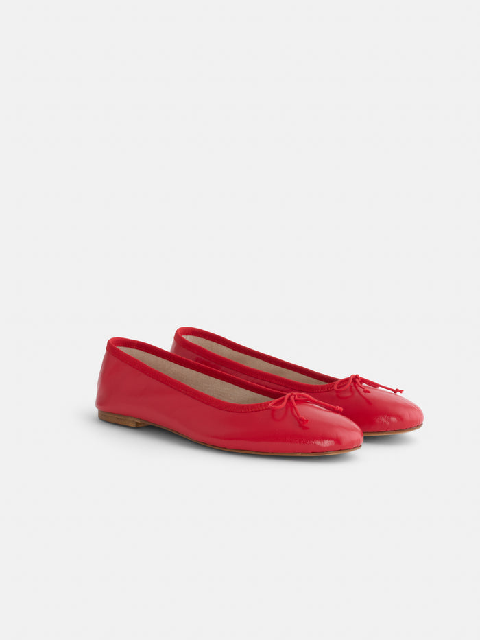 The Prince Street Ballet Flat is a shiny red Italian leather pair with small bows, handmade in Italy and displayed on a light background.