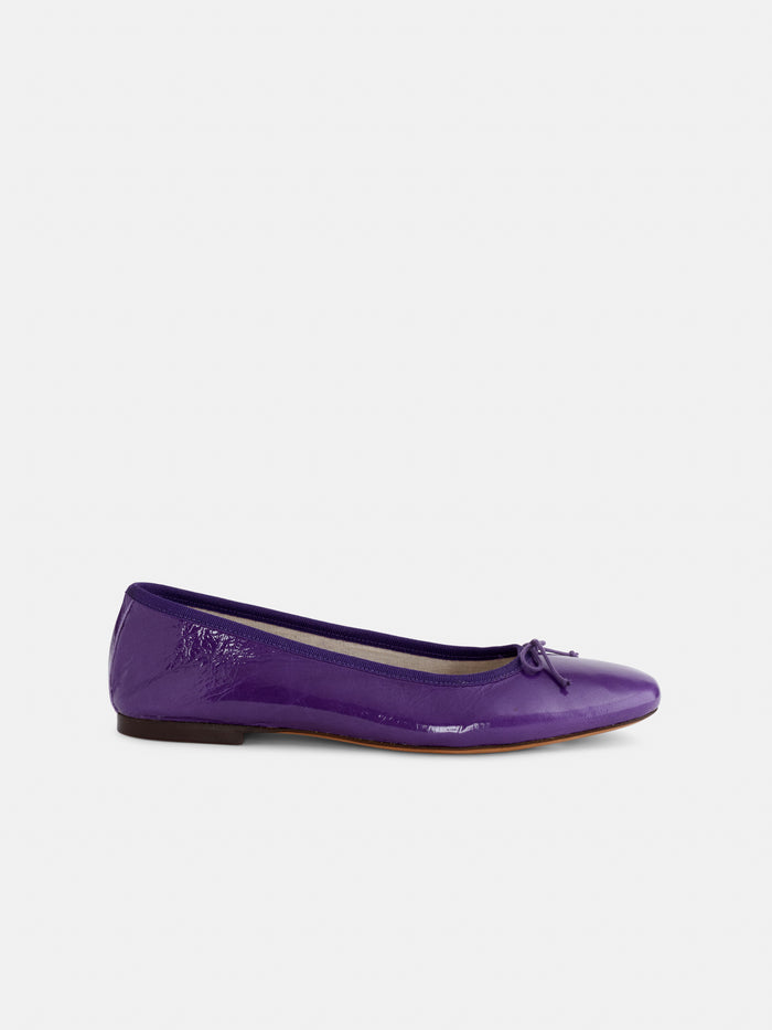 A single Prince Street Ballet Flat in patent leather, gleaming in rich purple and handcrafted in Italy from fine Italian leather, featuring a dainty bow at the toe—shown in profile against a plain white background.