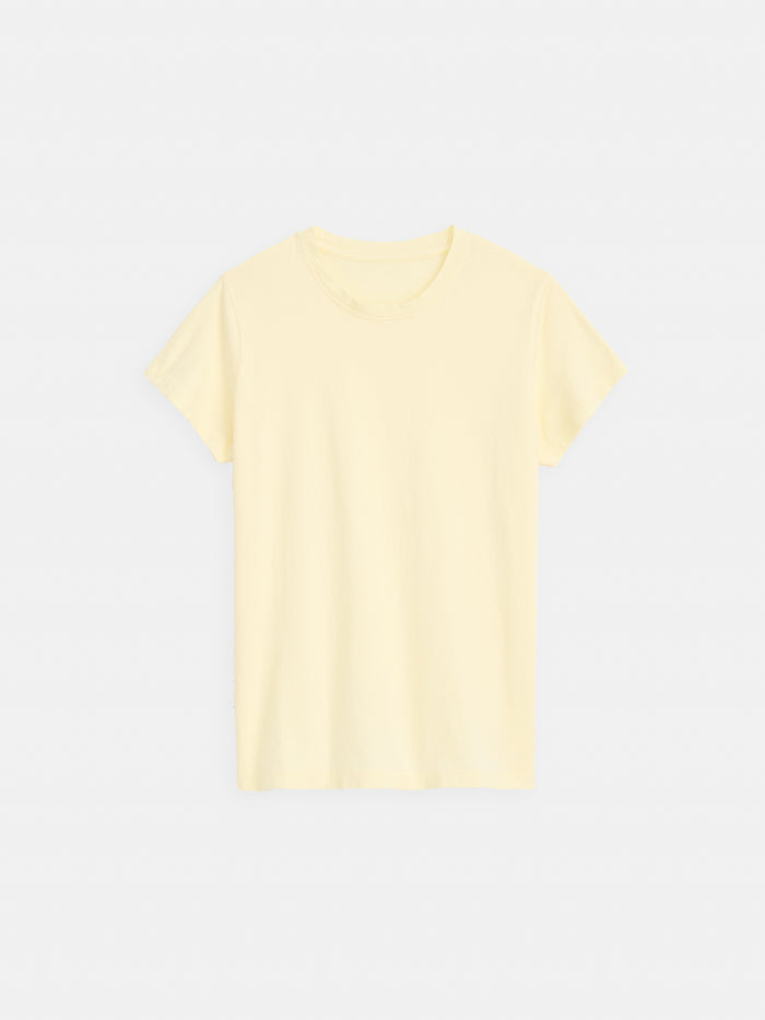 The Prospect Tee In Cotton Jersey is a plain, short-sleeved women’s shirt in light yellow with a classic crew neckline. Made in Peru from garment-dyed cotton jersey, it offers quality and comfort with no visible logos or designs.