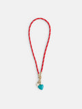 The Roxanne Assoulin Happy Cord Charm Necklace features a colorful cord with white accents, gold clasps, and two puffy heart pendants—one turquoise and one cream—dangling at the center.