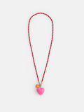 The Roxanne Assoulin Long Happy Cord Charm Necklace features a puffy heart pendant on a red and white cord, plus two detachable charms—a pink heart and a small orange heart—on gold rings. Background: white.