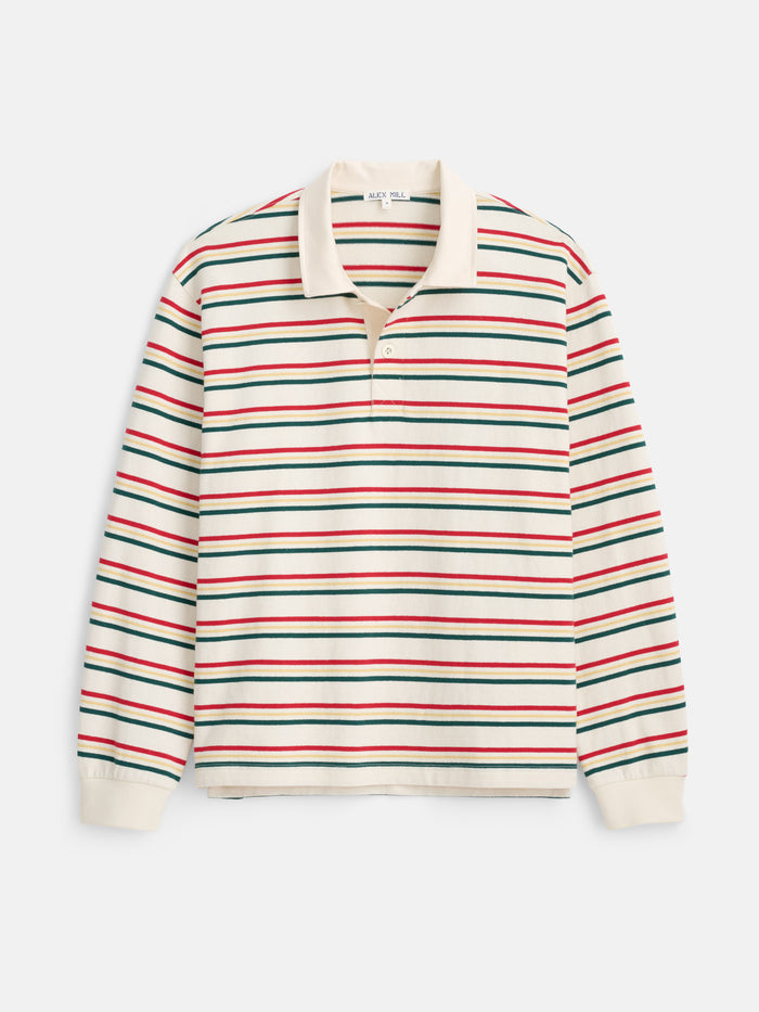 The Rugby Striped in Cotton Jersey is a long-sleeve, cream rugby shirt with a contrast collar and bold horizontal red, green, and black stripes. Made from soft herringbone cotton jersey, it features a buttoned placket, ribbed cuffs, and a slightly boxier fit for enhanced comfort.
