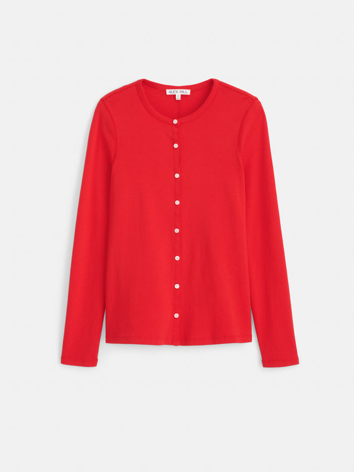 The Scout Cardigan in Cotton Rib is a vibrant red, long-sleeved cardigan featuring a round neckline and white buttons along the front, reminiscent of classic shell button blouses, and is displayed on a white background.
