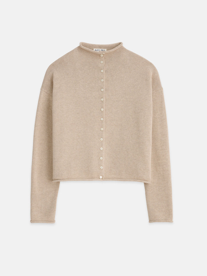 The Taylor Cardigan In Cotton Cashmere is a beige, long-sleeve women’s sweater with a high collar, front button closure, and slightly cropped hem. Soft and lightweight fabric makes it stylish for any occasion.