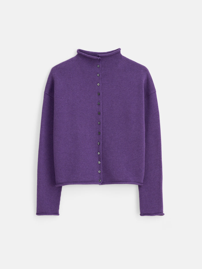 The Taylor Cardigan in Cotton Cashmere is a long-sleeve, purple button-up sweater featuring a mock neck and an oversized boxy fit. Crafted from a luxurious cotton-cashmere blend and finished with elegant Troca shell buttons, it is shown laid flat on a white background.