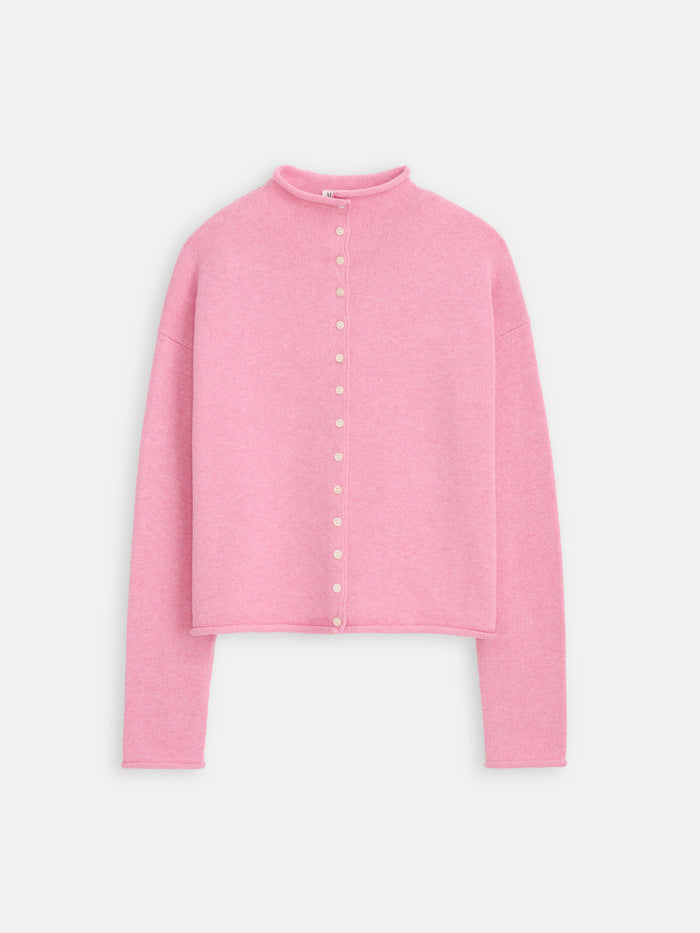 The Taylor Cardigan in cotton cashmere is a light pink, long-sleeve sweater with a mock neck, small white front buttons, an oversized boxy fit, and hand-finished details, shown on a white background.