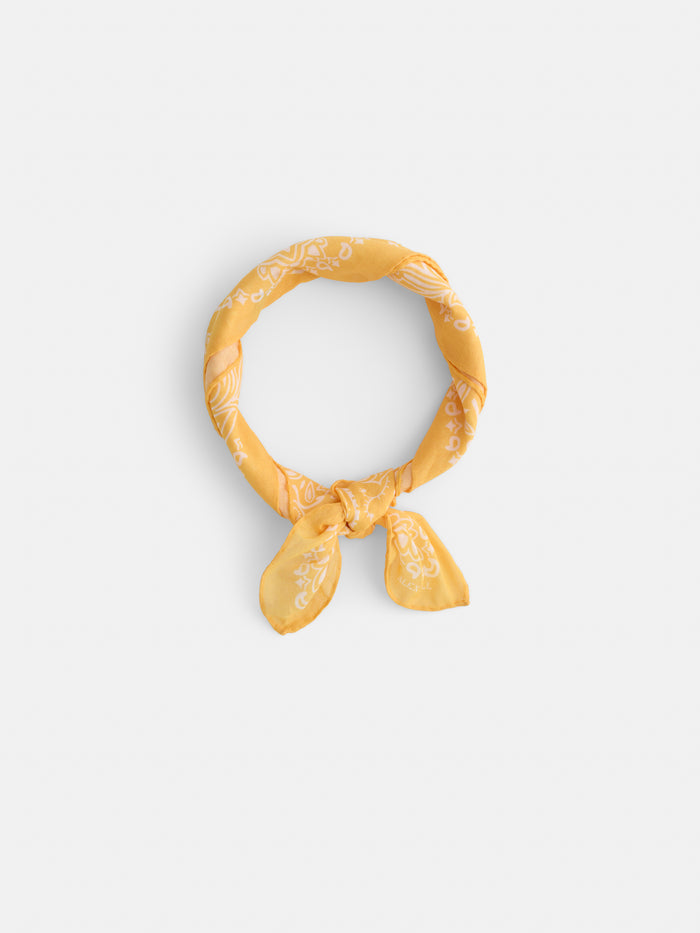 The Two Tone Bandana in Cotton, made in Italy, showcases yellow cotton voile with a white paisley pattern, tied simply and set against a plain white background.