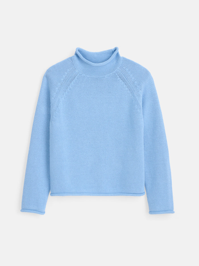 The Eastport Rollneck In Cotton is a light blue, long-sleeved sweater crafted from soft knit cotton and shown on a white background. It features a classic roll-neck design with ribbed collar and minimal detailing for an understated look.
