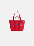 The Perfect Daily Tote is a red canvas cotton bag with two handles, featuring blue and white “SOM” lettering on the front. Set against a plain white background, this personalized tote is both stylish and functional.