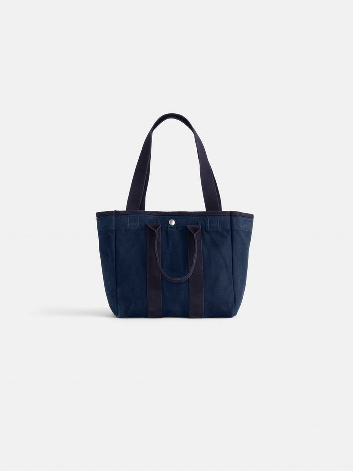 The Perfect Daily Tote: a navy blue canvas cotton tote with matching handles, shown upright on a white background. This monogrammable bag is a stylish and personalized option for everyday use.