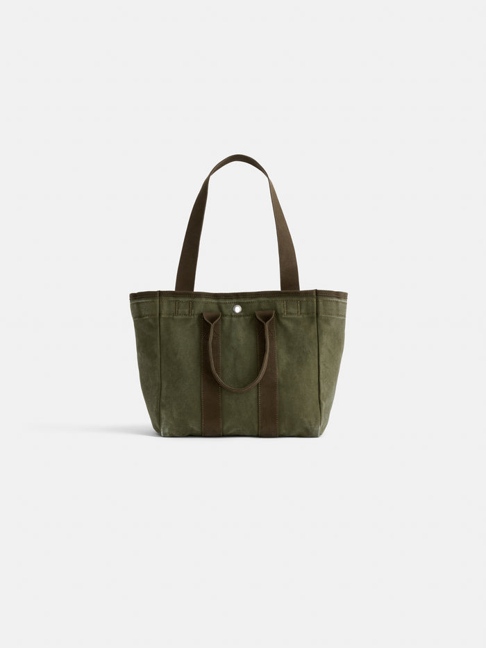 The Perfect Daily Tote in olive green cotton features two short handles, two long shoulder straps, simple stitching, and a single snap button closure—shown against a plain white background for an effortless look.