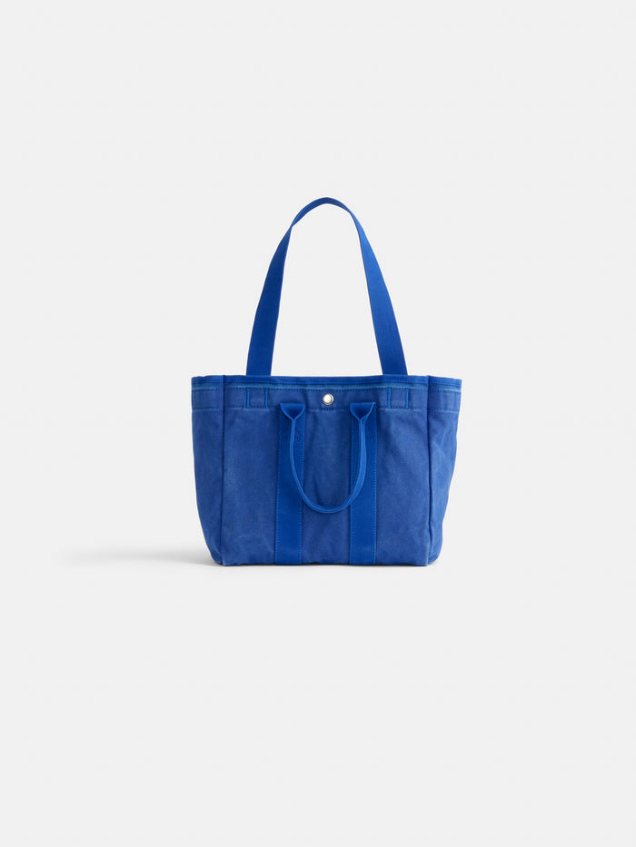 A blue cotton tote bag with two handles and a button closure, set against a plain white background—meet The Perfect Daily Tote, your ideal everyday carry from Alex Mill.