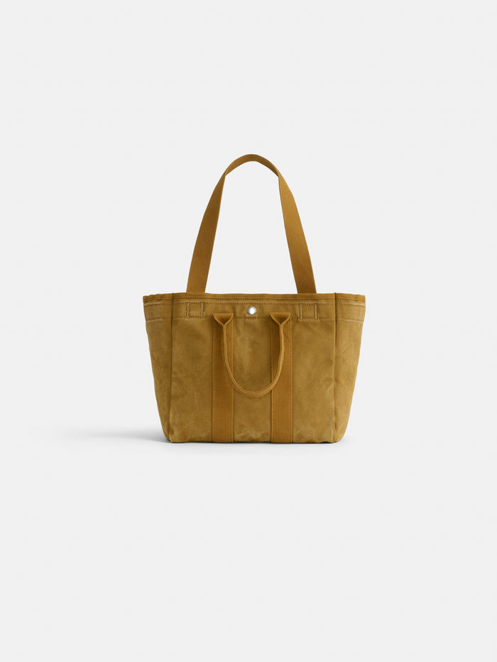 The Perfect Daily Tote is a mustard yellow cotton bag with two short handles and two long shoulder straps, ideal for everyday use. Shown here against a plain white background.