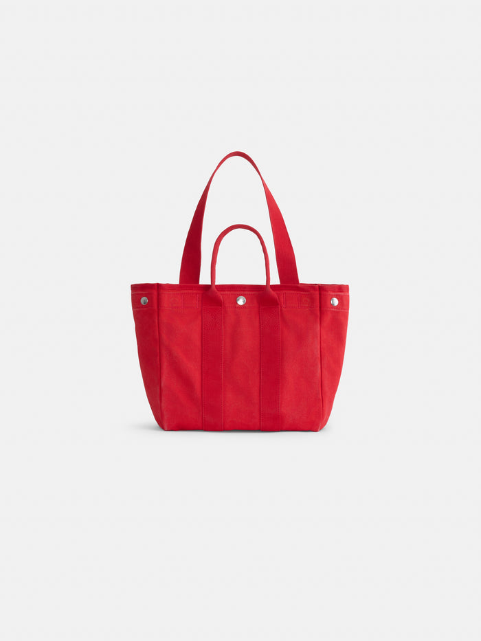 The Perfect Daily Tote is a vibrant red cotton bag featuring both short and long handles, silver button accents, and a structured rectangular silhouette. Displayed against a plain white background, it’s ideal for anyone looking for personalized totes or stylish monogrammable tote bags.