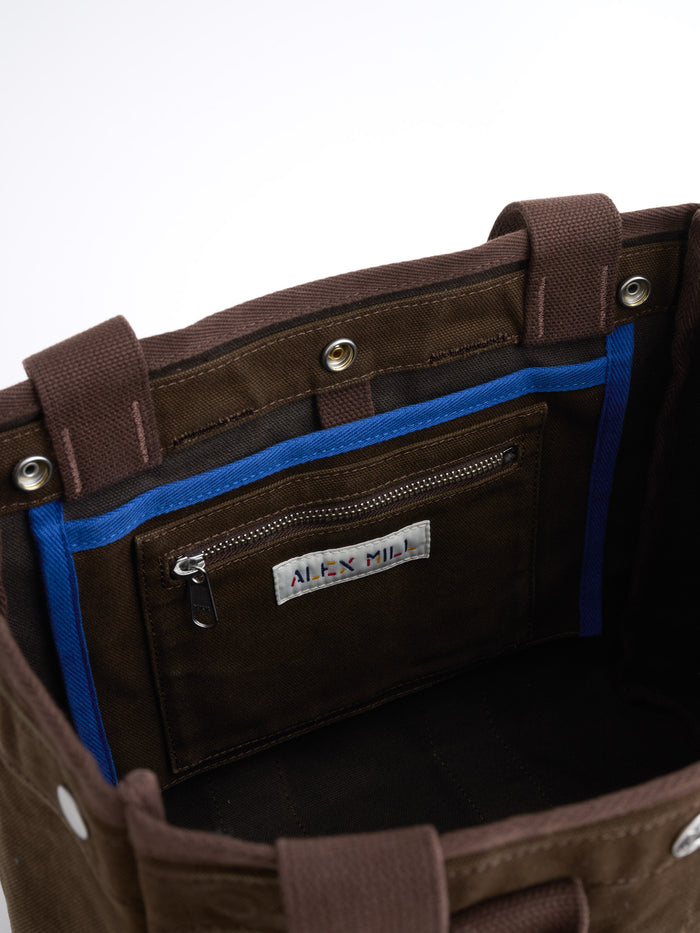 Introducing The Perfect Daily Tote: an open brown cotton tote bag featuring a blue-trimmed inner pocket, visible Alex Mill label, and matching brown handles—captured against a plain white background. This monogrammable piece is ideal for anyone seeking style and practicality.