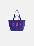 Introducing the Painted Perfect Weekday Tote—a purple bag with two handles and silver rivets, adorned with bold red and white “SMP” lettering on the front. This stylish accessory is perfect for anyone who loves personalized totes and monogrammable bags.