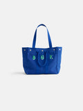 Introducing The Perfect Weekday Tote: a blue cotton bag with two sturdy handles, front snap buttons, and the letters B G K elegantly embroidered in green and white on the front—ideal for anyone who loves personalized accessories or is searching for a monogrammable tote bag.