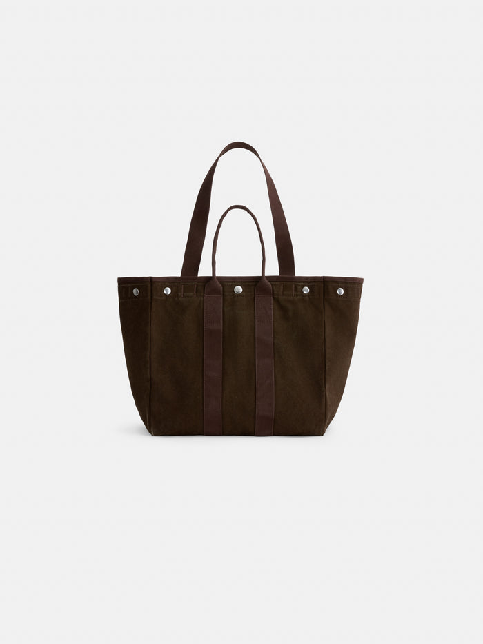 The Painted Perfect Weekday Tote—a dark brown canvas bag featuring two short handles, two long shoulder straps, and silver button accents—is ideal for those seeking personalized totes and is displayed against a plain white background.