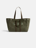 The Perfect Weekend Tote is a large olive green cotton bag with brown handles and trim, featuring "LHR" in white and green on the front. It includes personalized details and metal snaps near the top edges.