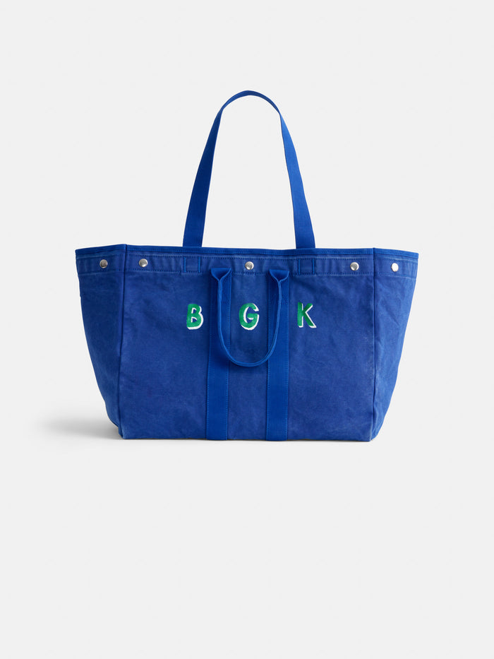 Introducing The Perfect Weekend Tote: a spacious blue cotton tote bag featuring two sturdy handles and customized green and white “BGK” embroidery on the front—making it the ideal personalized accessory for any occasion.