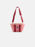 The Striped Mini is a small tote with red and white stripes, red handles, an adjustable red shoulder strap, and a blue "M" monogram on the front pocket.