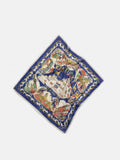 A vibrant Travel Scarf In Cotton Voile with a blue border, showcasing an illustrated map of Capri, Italy alongside iconic landmarks and floral motifs. Evoking the charm of a vintage bandana, the scarf is displayed flat against a white background.