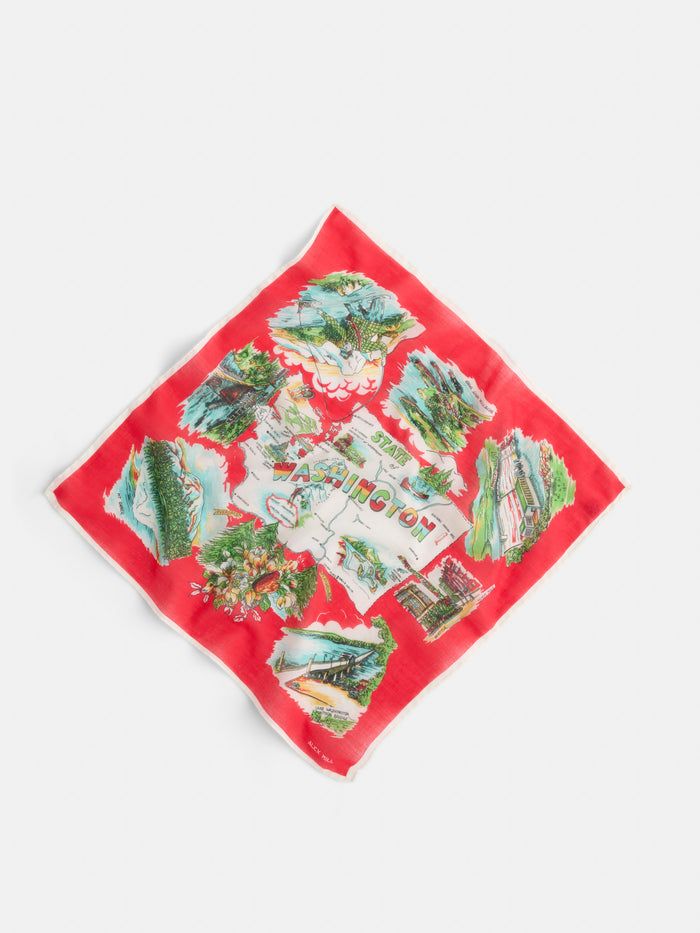 The Travel Scarf In Cotton Voile is a red handkerchief featuring illustrated Washington landmarks and scenery around a central map with "Washington" in colorful letters, crafted from soft cotton voile.