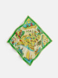 The Travel Scarf In Cotton Voile is a colorful square scarf featuring illustrated Maine landmarks, sailboats, and scenery. Bordered in green with "MAINE" at the top center, this vintage bandana is shown laid flat on a white background.
