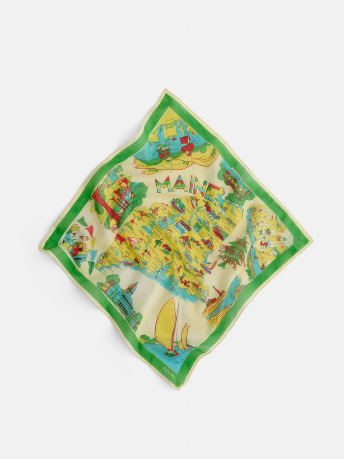 The Travel Scarf In Cotton Voile is a colorful square scarf featuring illustrated Maine landmarks, sailboats, and scenery. Bordered in green with "MAINE" at the top center, this vintage bandana is shown laid flat on a white background.