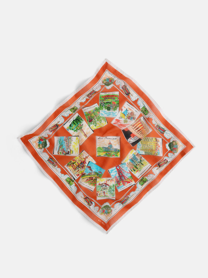 The Travel Scarf in Cotton Voile features a square design with an orange border and colorful postcard-style prints of iconic European landmarks, all arranged in a circular pattern for a charming vintage bandana vibe.