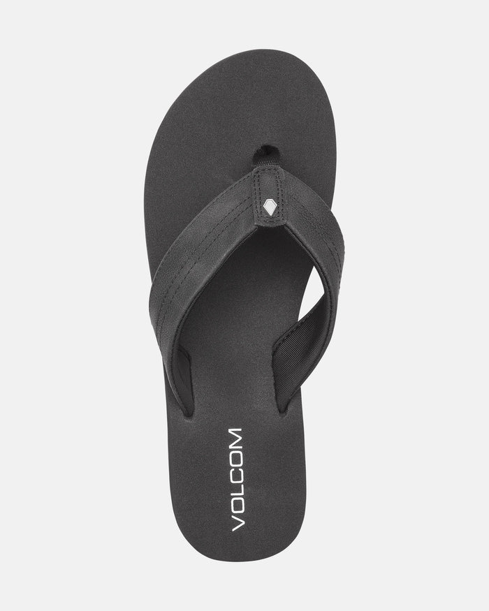 The Women's Boyfriends Thong by Volcom is a black sandal with wide straps and the Volcom logo in white on the comfort foam footbed, shown from above on a white background.