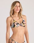 A woman with long blonde hair wears the Volcom Women's Distant Tropic Twist Bralette, a floral bikini top made from recycled nylon with thin straps and a knotted front. She has a neutral expression against a light, plain background.