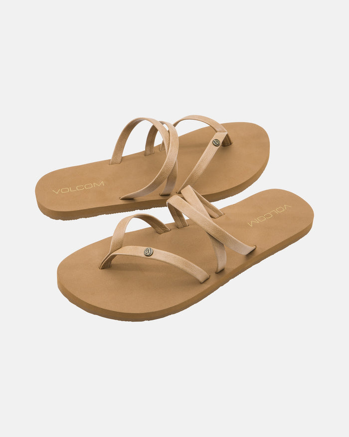 The Volcom Women's Easy Breezy II sandals feature a tan color, flat soles, multiple thin crisscrossing straps, and a comfortable EVA footbed, shown on a white background.